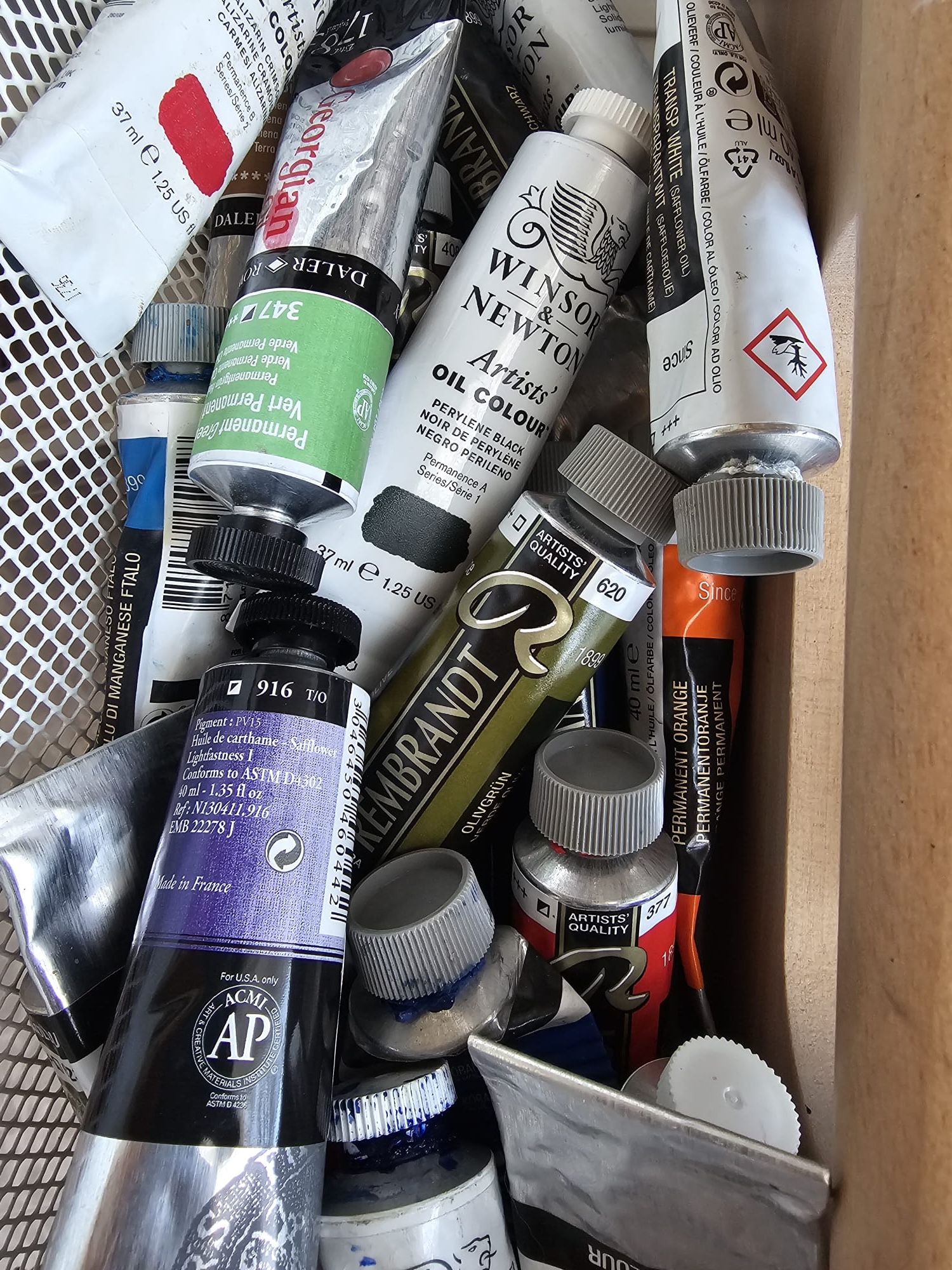 Oil paint tubes arranged on a studio surface.